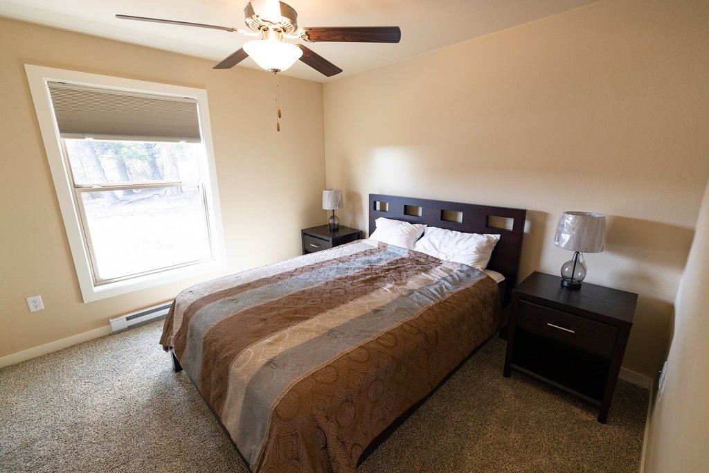 Bedroom with a ceiling fan and window shades