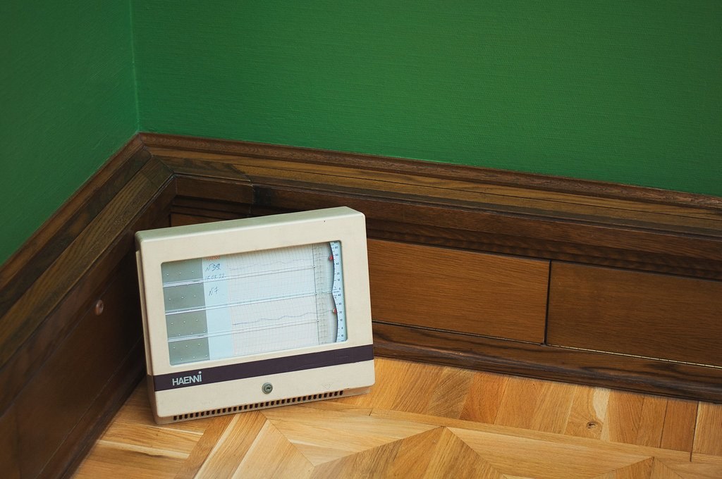 Room humidity monitor sitting on a wooden floor