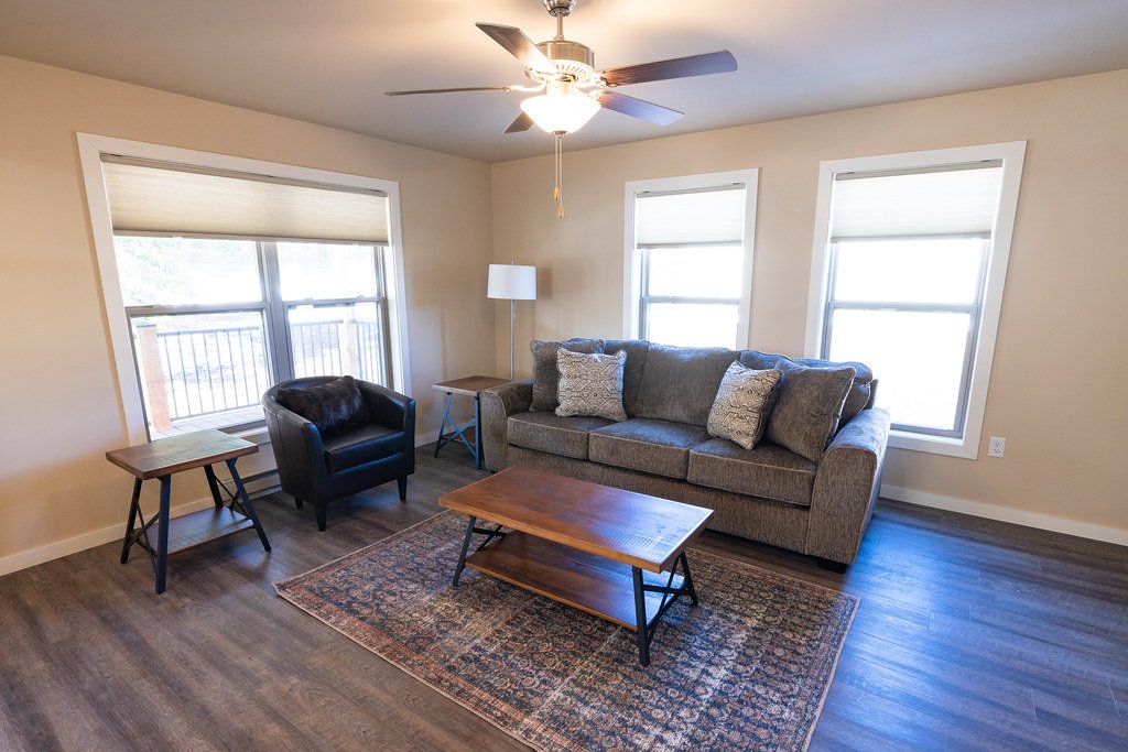 Open living room with windows and a ceiling fan