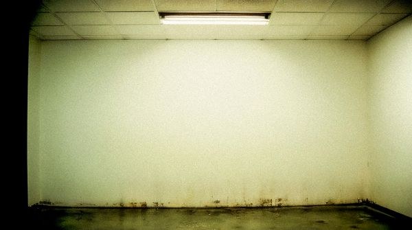 Room with dark moisture staining along the base of the walls
